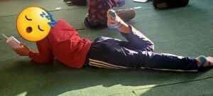 西日が差す大部屋に寝転んで、気持ちよさそうな子ども。