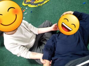 B君がA君のほほに手を当て返している