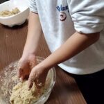 味噌づくりで完成間近の味噌をこねる子ども