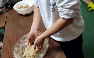 味噌づくりで完成間近の味噌をこねる子ども