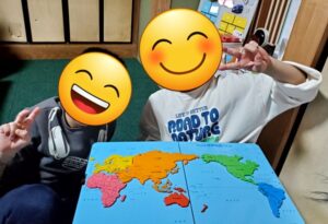 ぽらりすのお兄ちゃんが、年下の子どものパズルを手伝い、二人で完成させてピース。