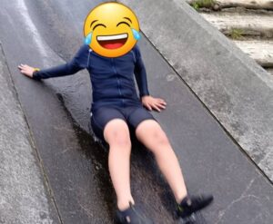 糟屋郡篠栗町の鳴淵ダムの川のすべりだいで、お子様が笑顔で滑っている